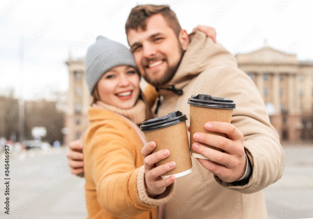 Young couple drinking coffee outdoors