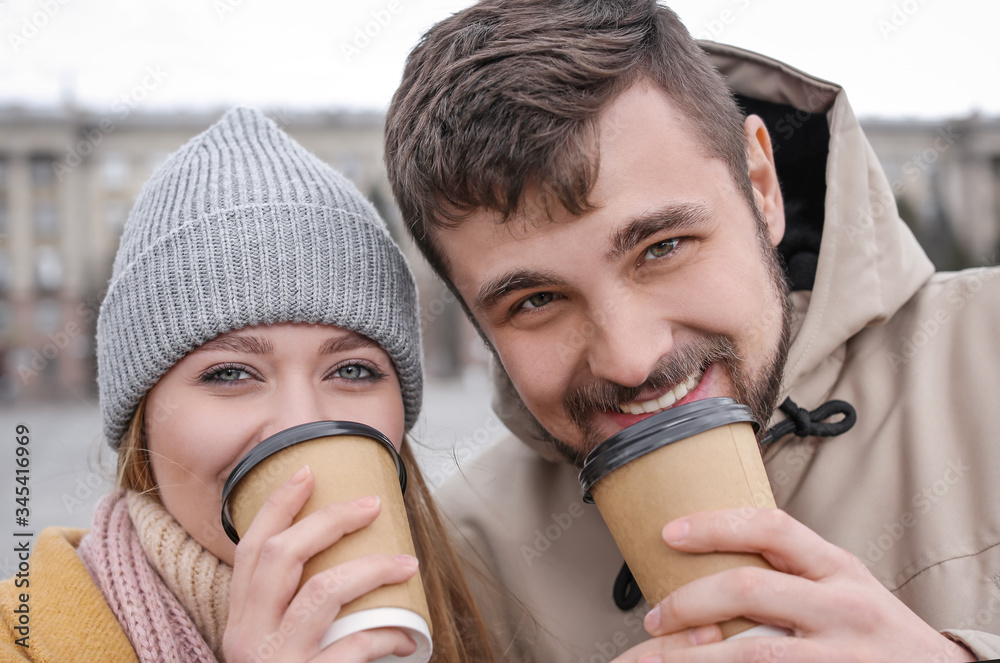 Young couple drinking coffee outdoors