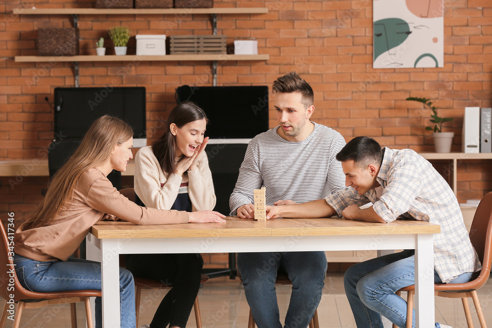 Team of business people playing jenga in office