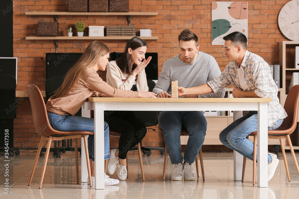 Team of business people playing jenga in office