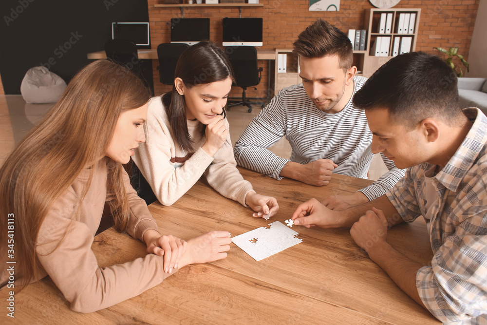 Team of business people doing puzzle in office