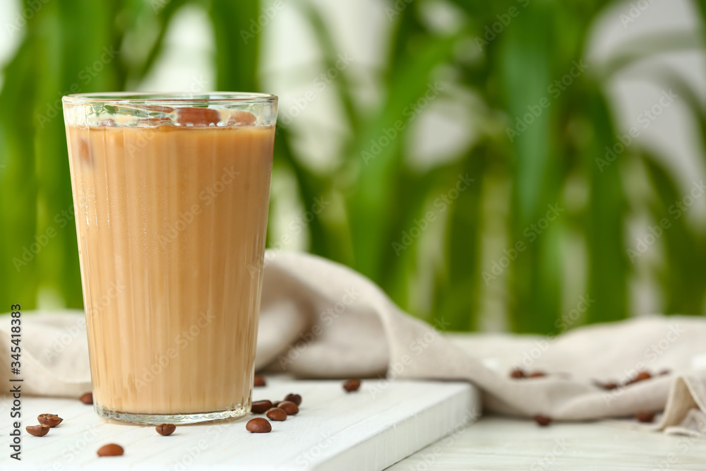 Glass of tasty iced coffee on table