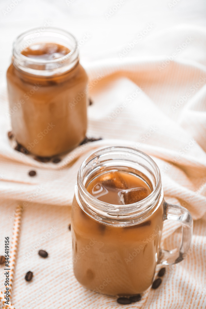 Mason jar of tasty iced coffee on table