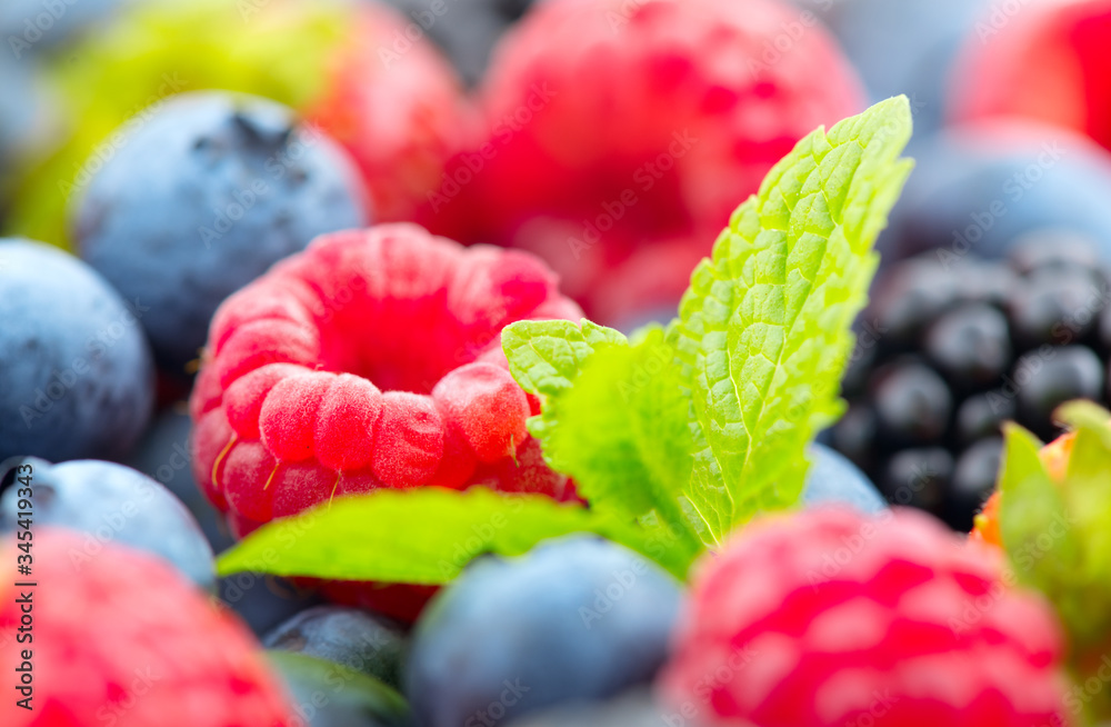 Berries. Various colorful berries background. Mint leaves, Strawberry, Raspberry, Blackberry, Bluebe