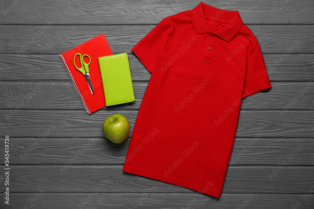 Stylish school uniform with stationery on dark wooden background