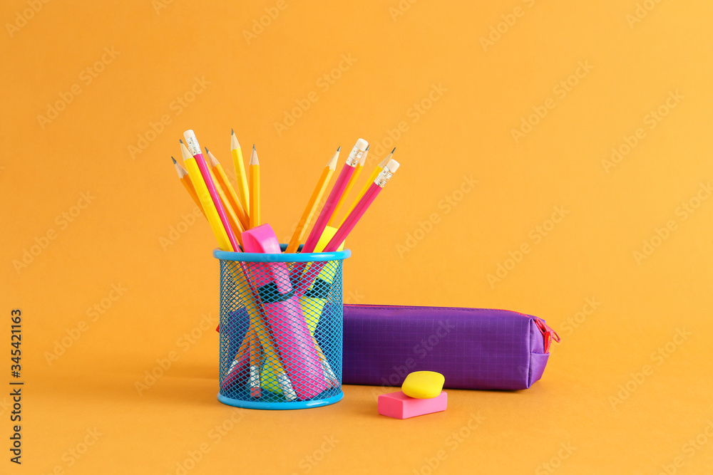 Holder with stationery on color background