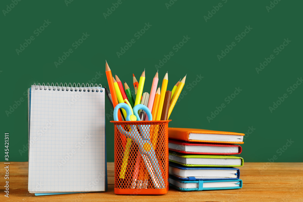 Holder with stationery on table in classroom