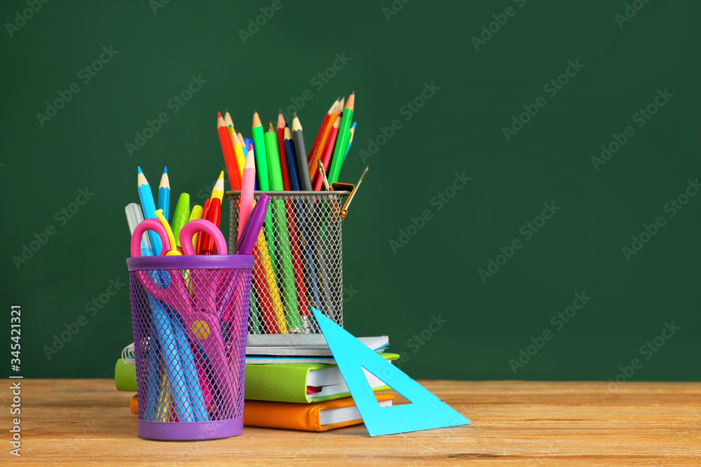 Holders with stationery on table in classroom