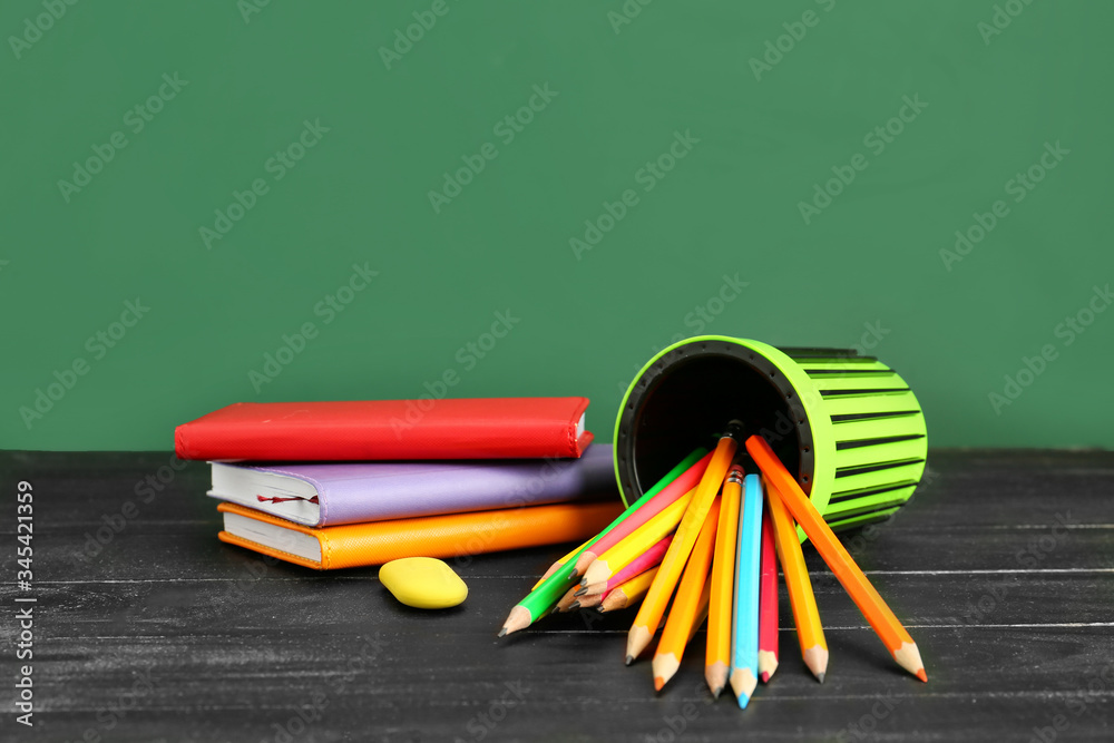 Holder with stationery on table in classroom