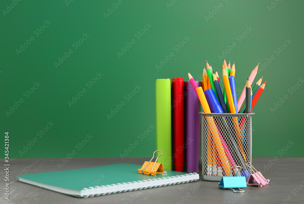 Holder with stationery on table in classroom