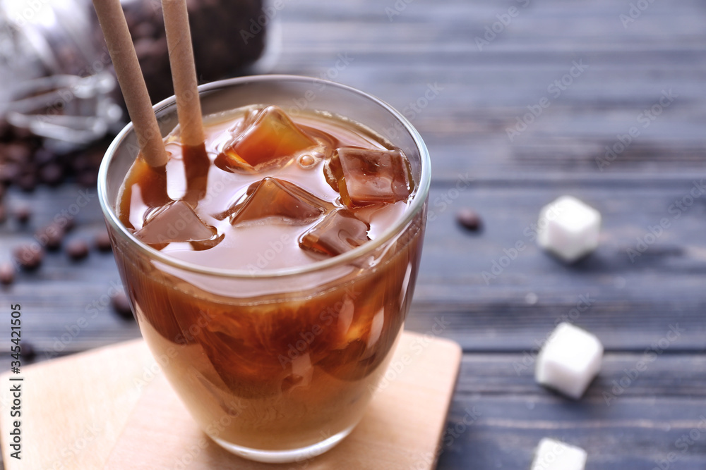 Glass of tasty iced coffee on table