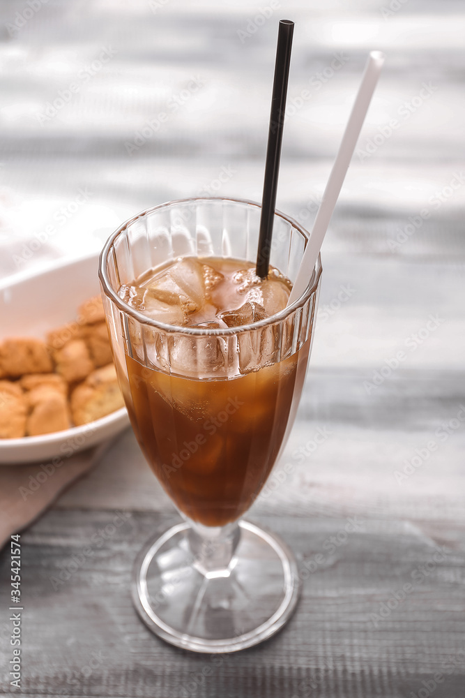 Glass of tasty iced coffee on table