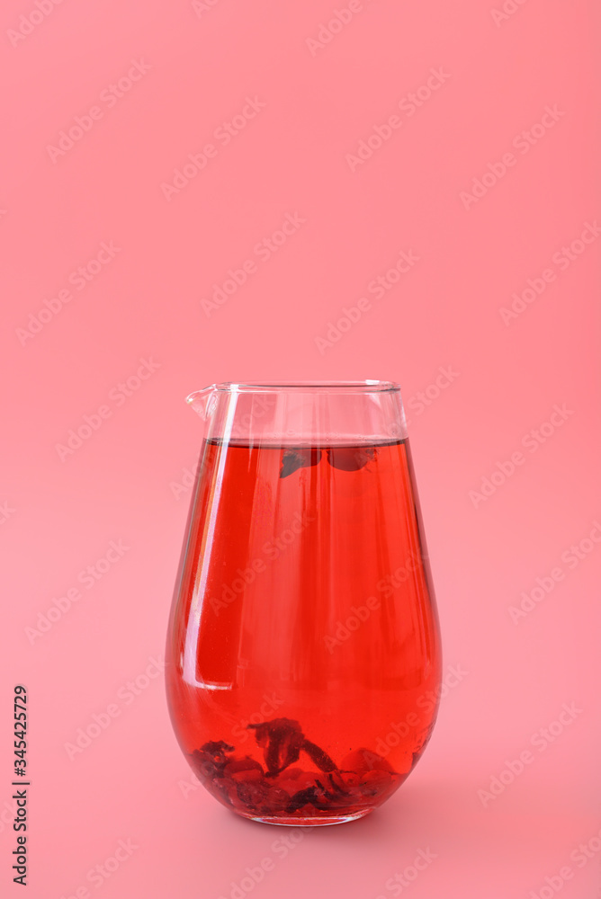 Jug of tasty cold ice tea on color background