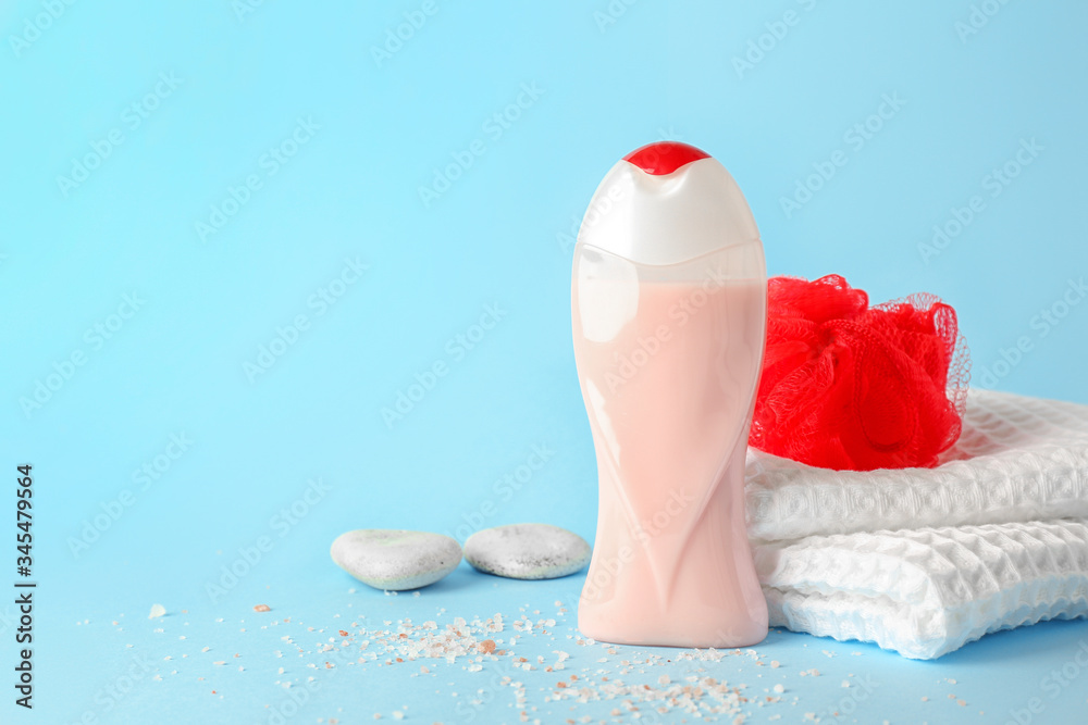 Shower gel, towel and loofah on color background