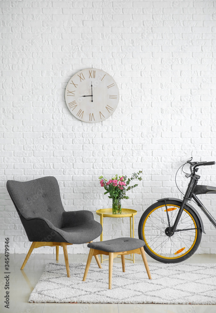 Interior of modern living room with comfortable armchair, table and bicycle