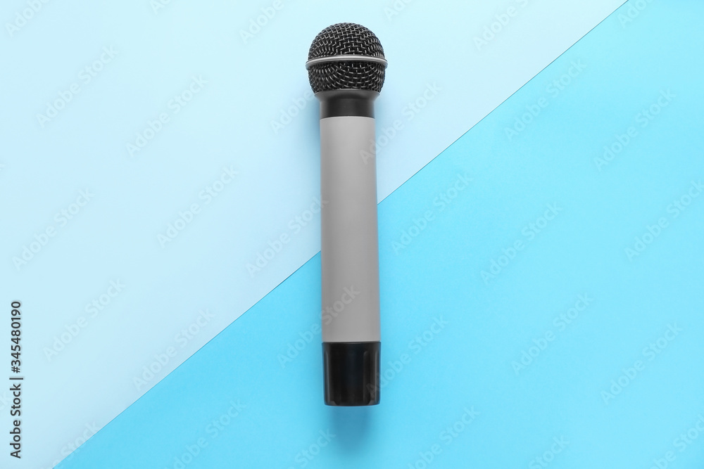 Modern microphone on color background