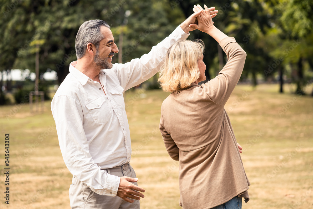 Lifestyle, senior elderly retirement couple dancing together in park. Old man holding woman hip and 