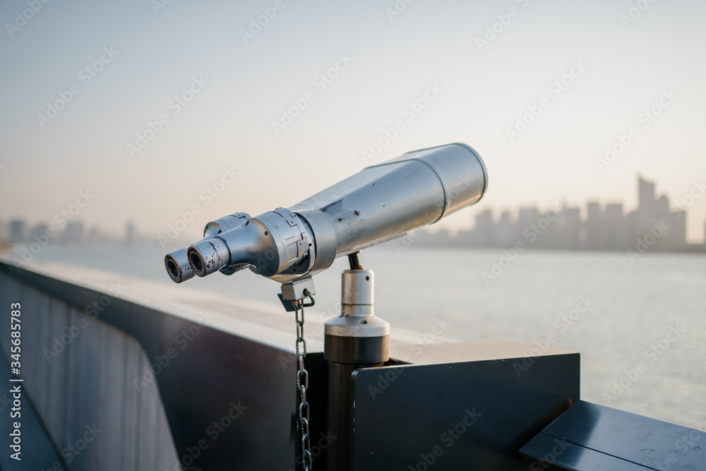 telescope with city skyline