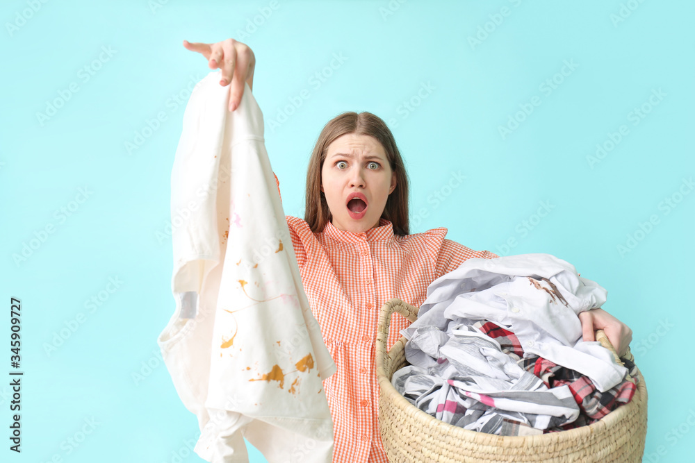 Troubled woman with dirty clothes on color background