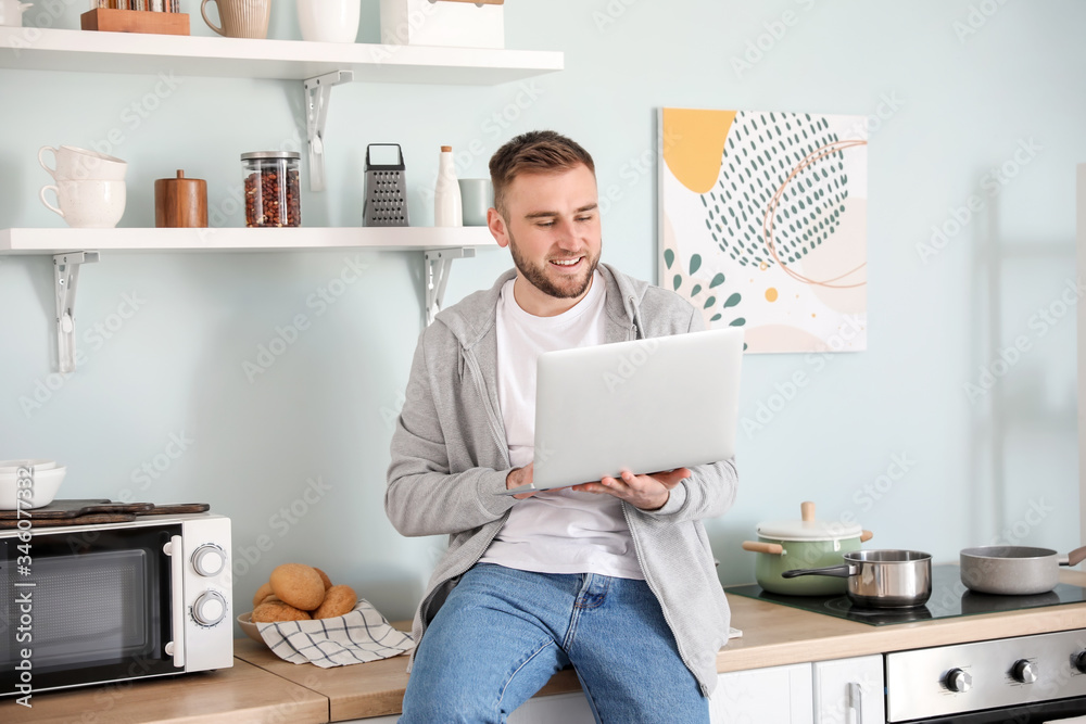 Young man with laptop working at home