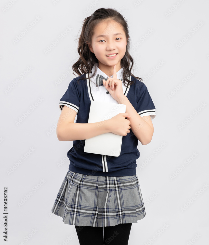 Asian primary  school girls in school uniforms on a gray background