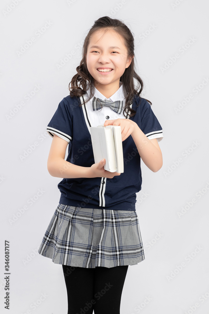 灰色背景下穿着校服的亚洲小学女生