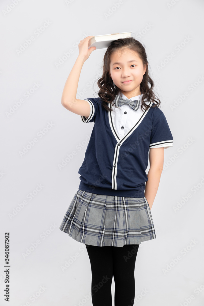 灰色背景下穿着校服的亚洲小学女生