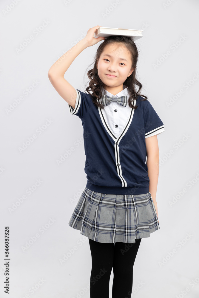 灰色背景下穿着校服的亚洲小学女生