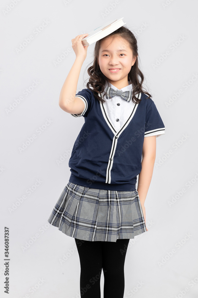 灰色背景下穿着校服的亚洲小学女生