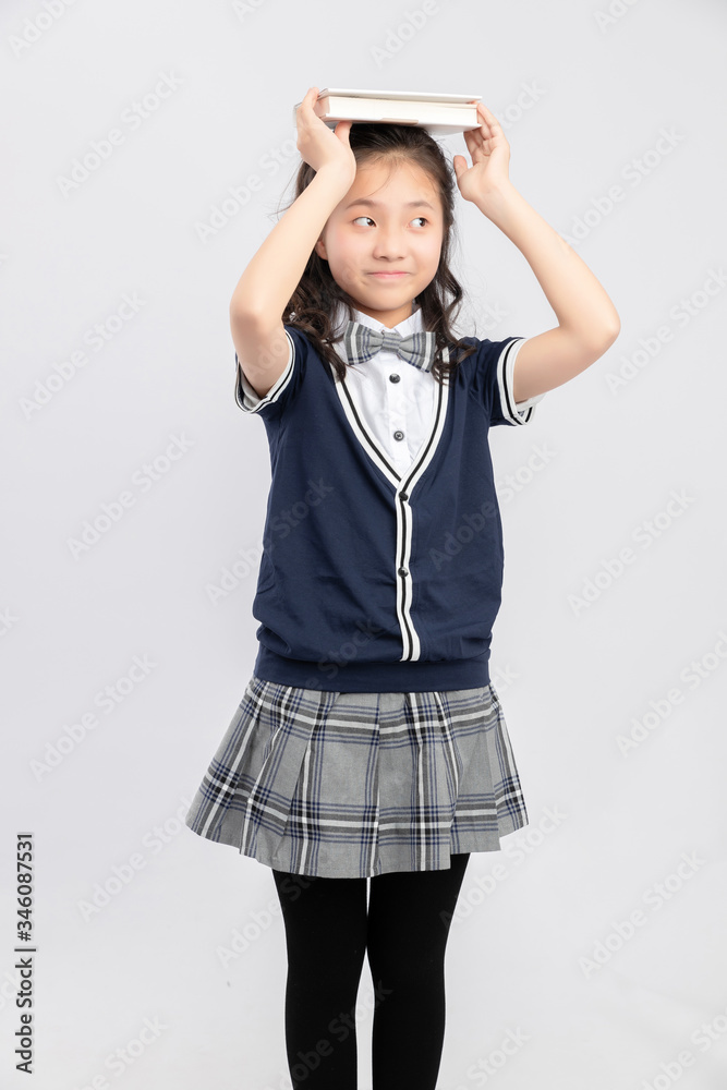 灰色背景下穿着校服的亚洲小学女生