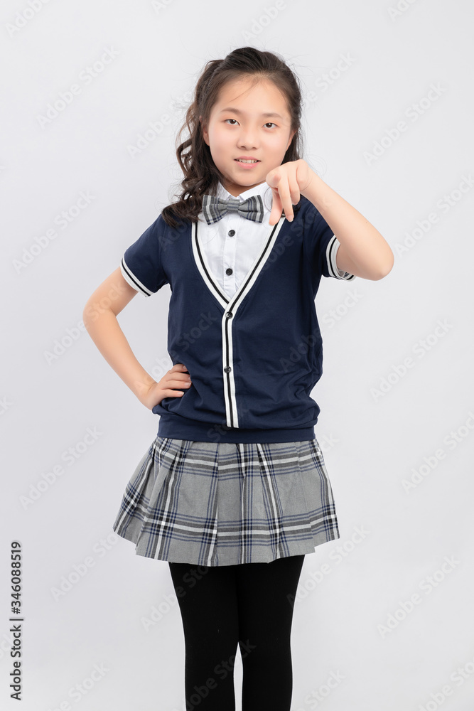 灰色背景下穿着校服的亚洲小学女生