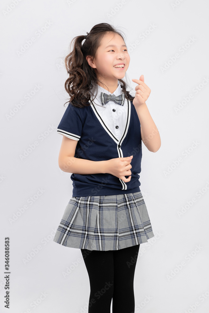 灰色背景下穿着校服的亚洲小学女生