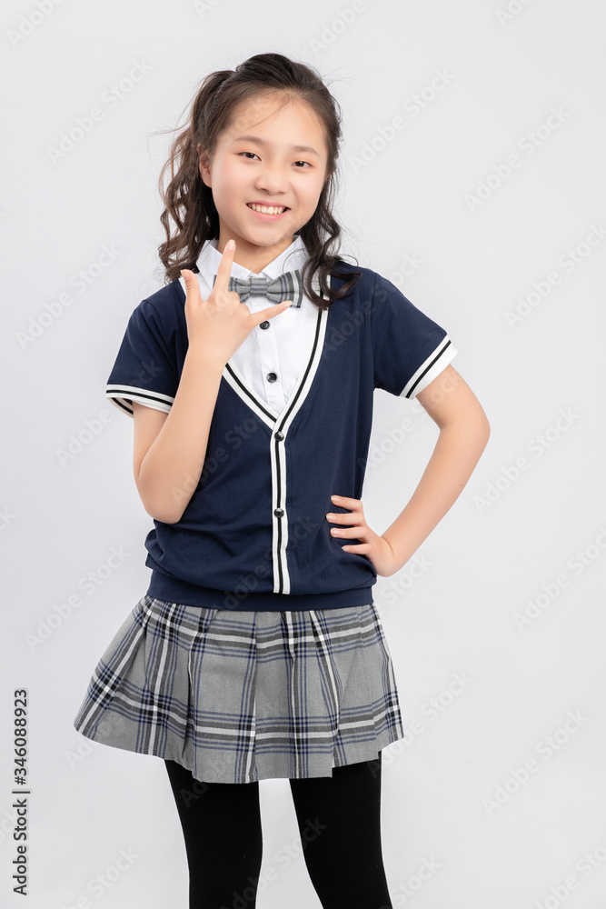 灰色背景下穿着校服的亚洲小学女生