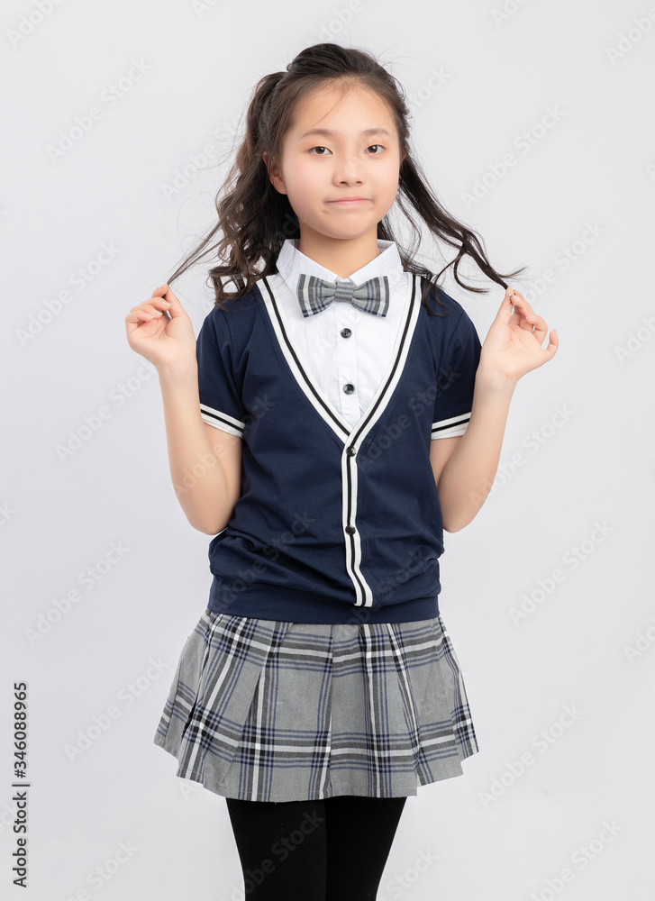 灰色背景下穿着校服的亚洲小学女生