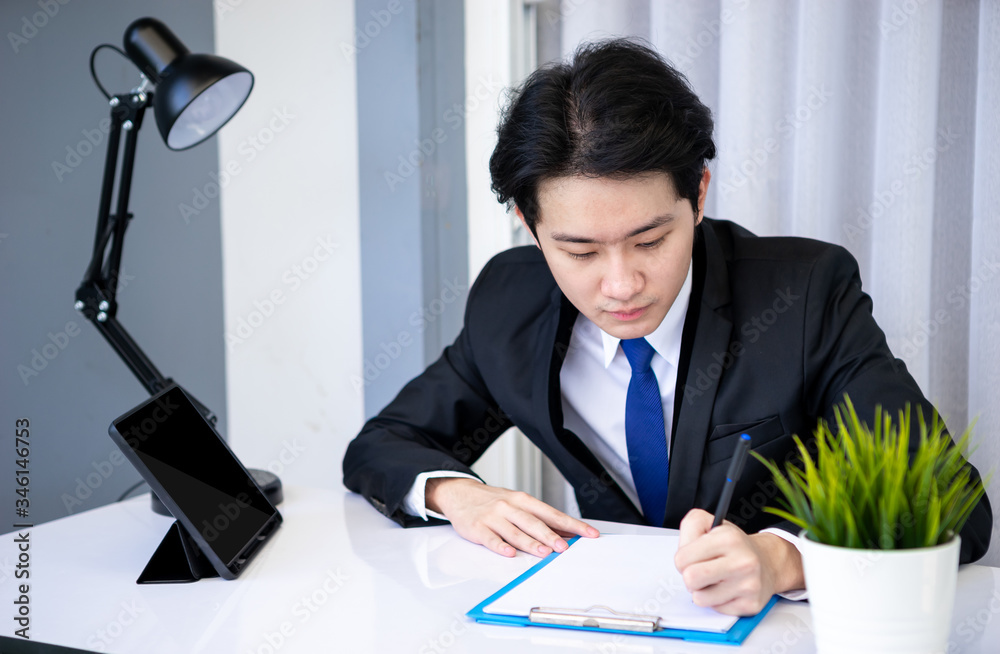 Asian business man dringking coffee wearing suit, enjoying watching educational webinar on laptop or