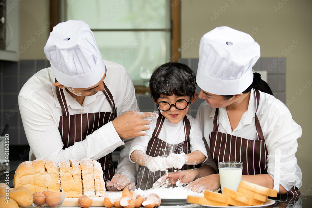 Happy  asian family   in apron chef hat preparing baking the dough in kitchen room at home