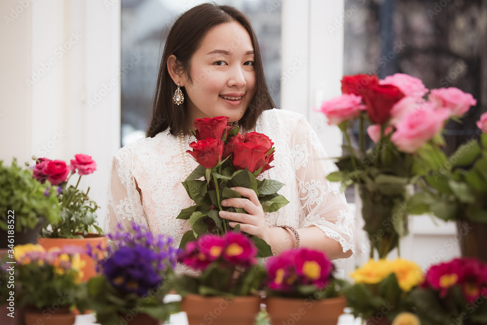 准备在家里修剪红色和粉色玫瑰以及美丽的插花的女人，花arr