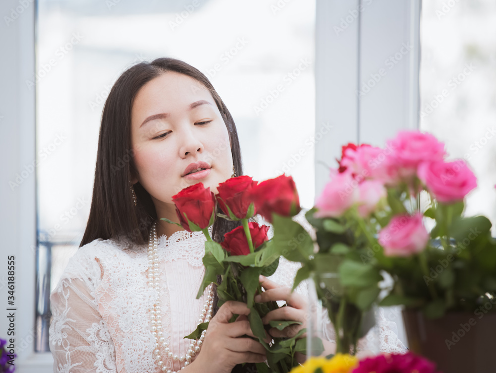 准备在家里修剪红色和粉色玫瑰以及美丽的插花的女人，花arr