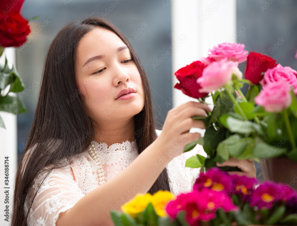 准备在家里修剪红色和粉色玫瑰以及美丽的插花的女人，花arr