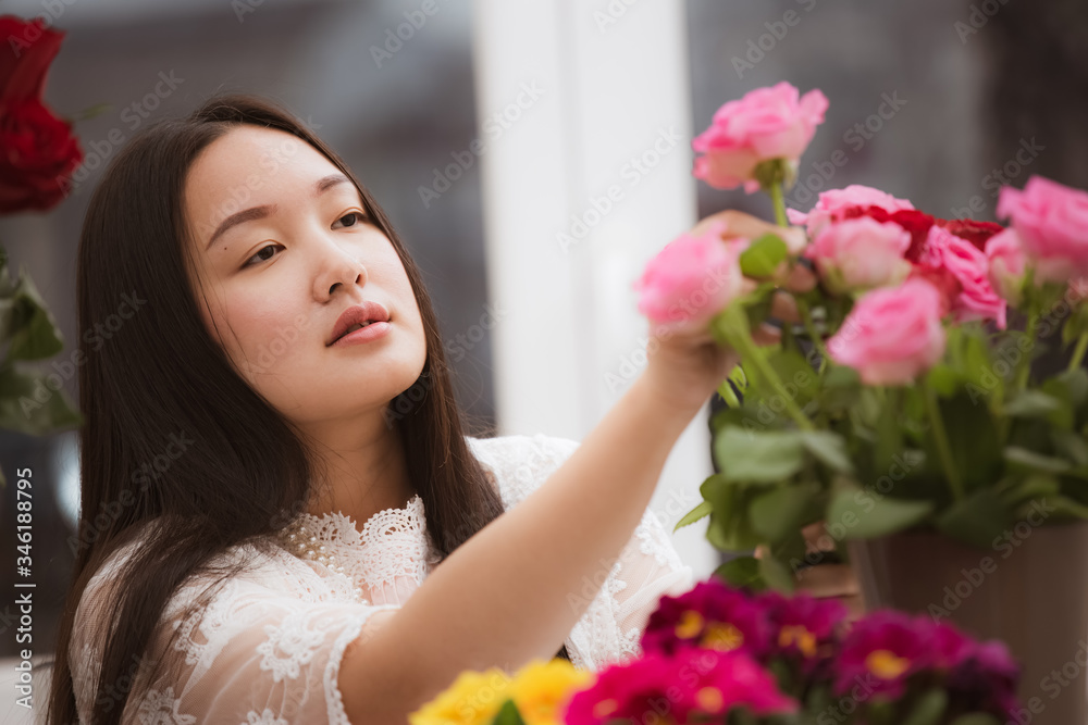 准备在家里修剪红色和粉色玫瑰以及美丽的插花的女人，花arr