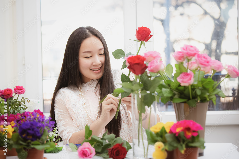 准备在家里修剪红色和粉色玫瑰以及美丽的插花的女人，花arr