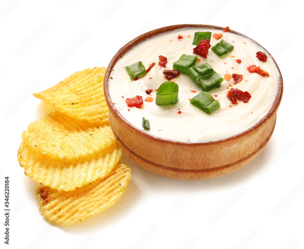 Bowl with tasty sour cream and potato chips on white background