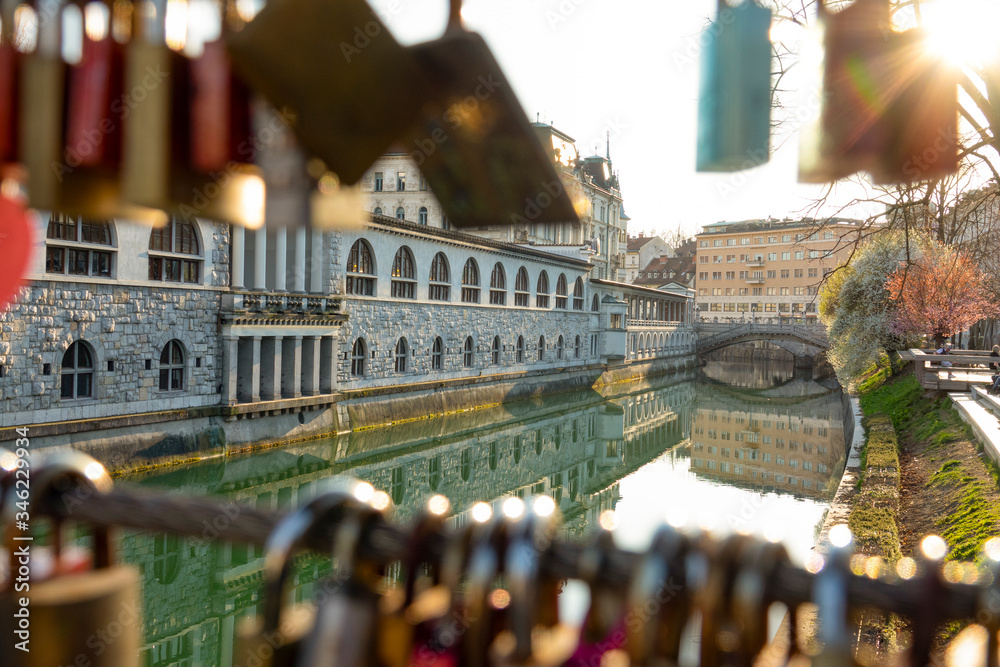 CLOSE UP: Golden sun rays shine on locks locked on wires of Butchers bridge.