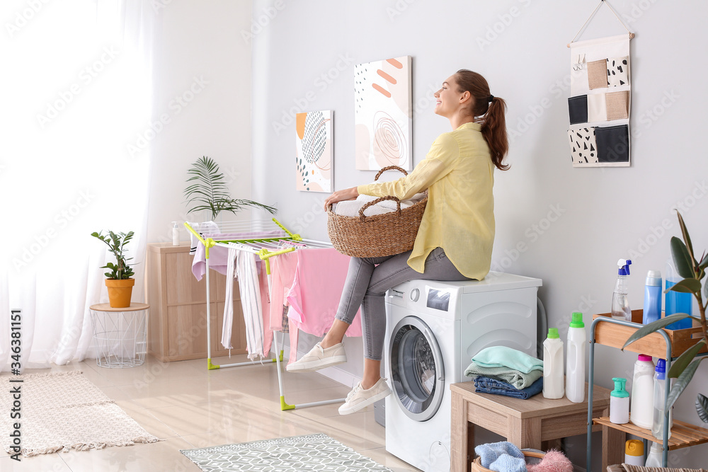 Young woman doing laundry in bathroom