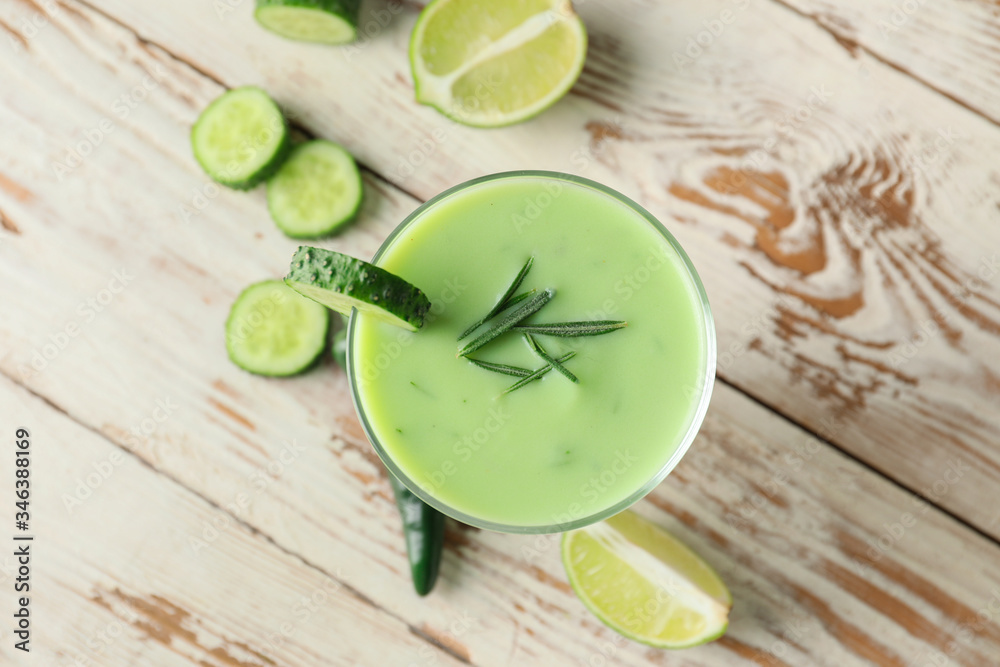 Glass with cold cucumber soup on table