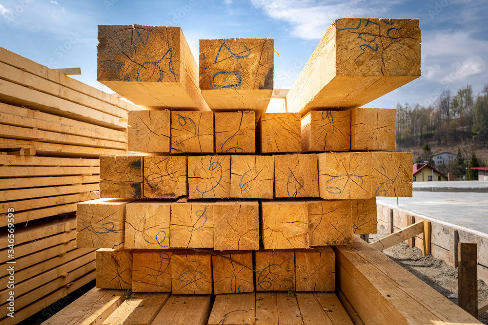 Stack of wooden beams on construction site prepared for building a house