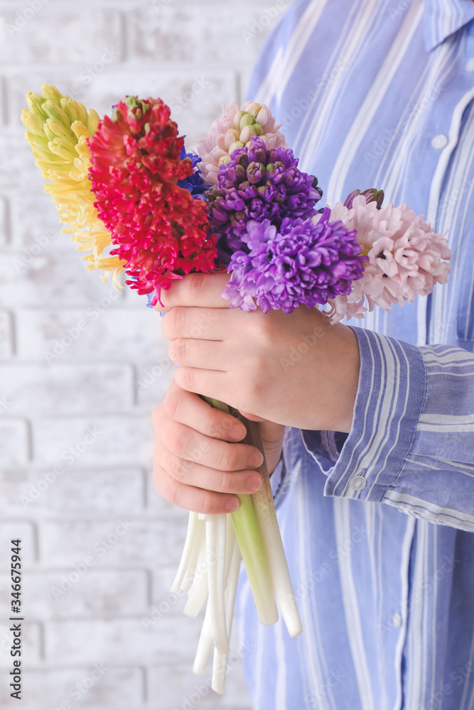 砖背景上开着漂亮风信子花的女人，特写