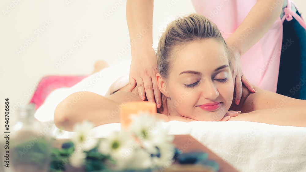 Relaxed woman getting back massage in luxury spa with professional massage therapist. Wellness, heal