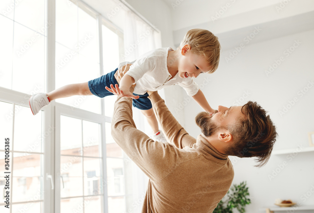 Happy man with little son having fun at home