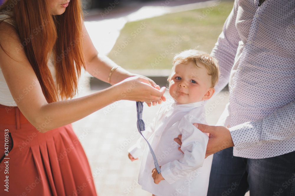 mom and dad dress up their son on the street